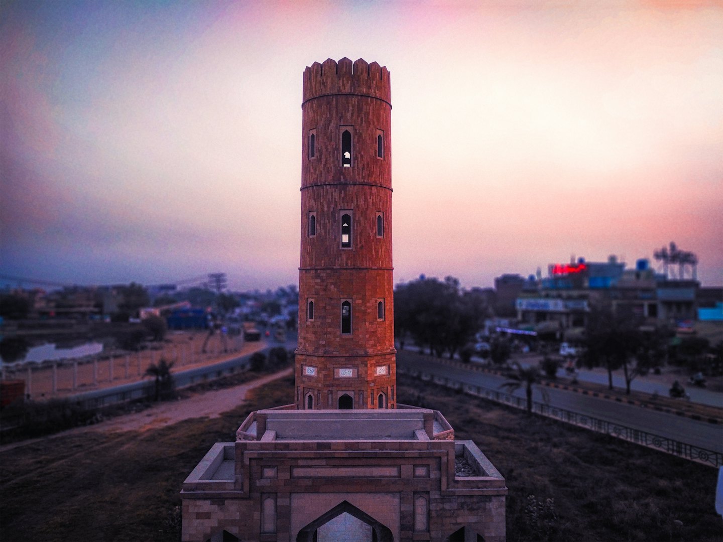 A historical brick tower stands against a twilight sky.