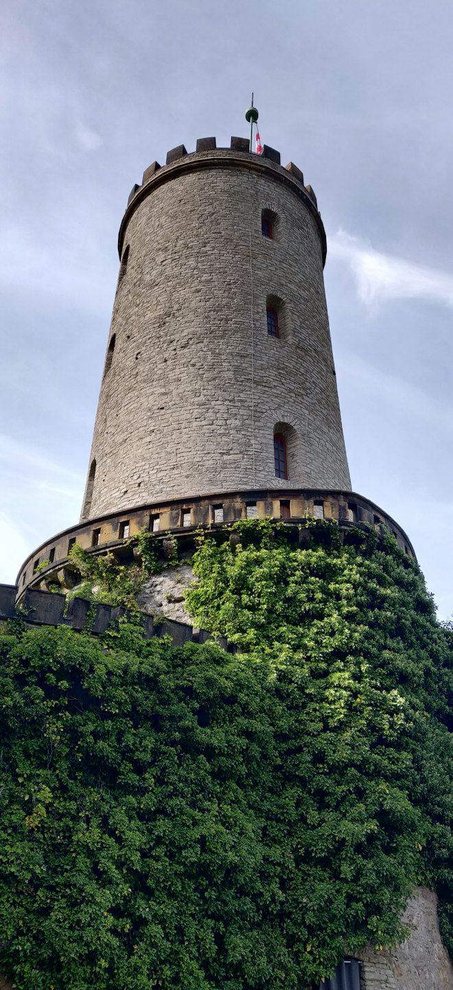 Ivy covers the stone walls of a tall medieval tower.